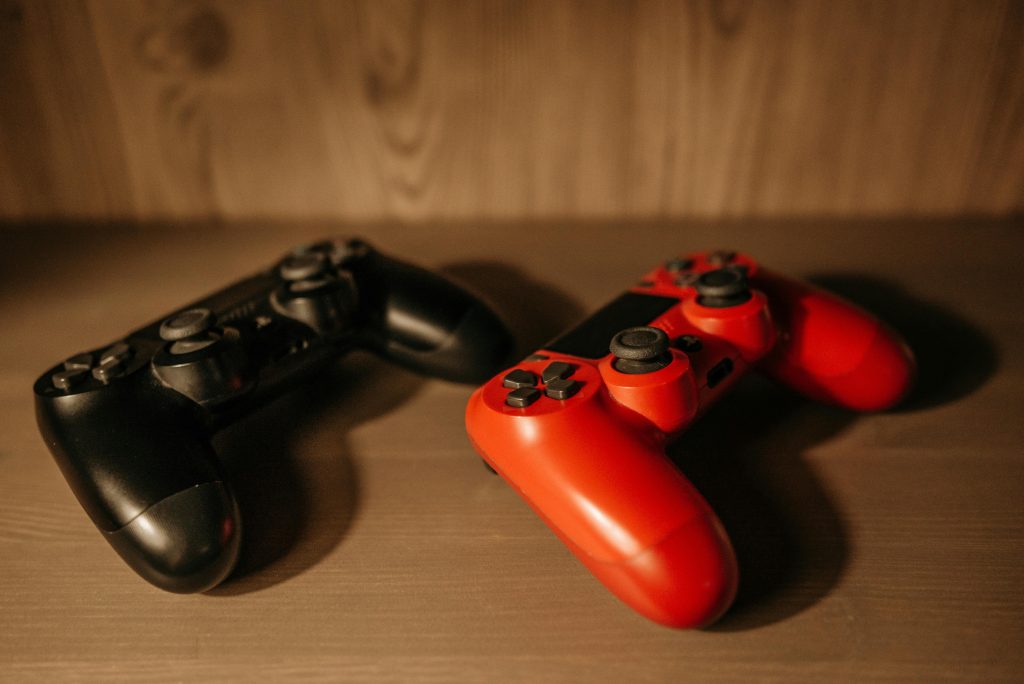 Detailed image of red and black game controllers on a wooden surface.